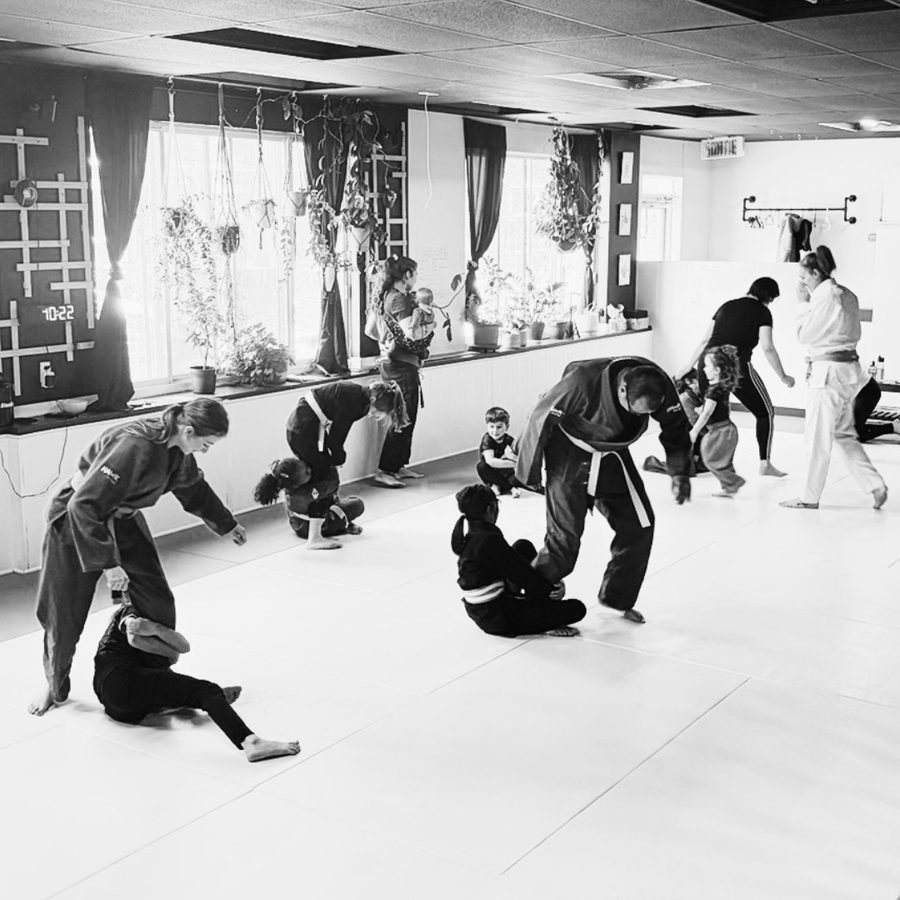 Parents et enfants pratiquant des mouvements de jiu-jitsu ensemble pendant un cours Parents-enfants