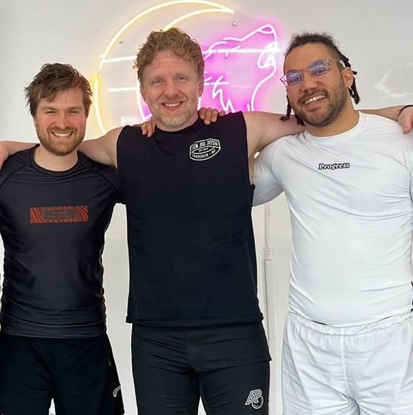 Émile, Souders et Momo, bras dessus bras dessous, souriants au gym